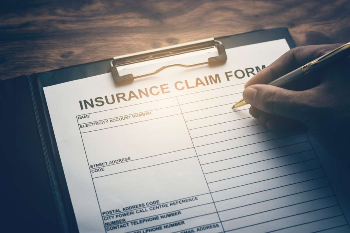 An insurance claim form on a clipboard, roof insurance claim concept