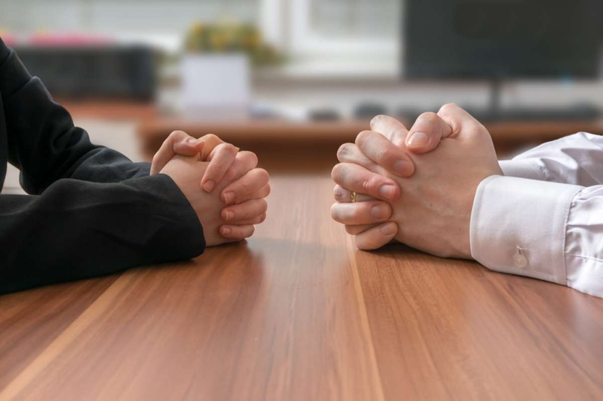 Close-up of hands on a table, negotiating with insurance adjusters concept