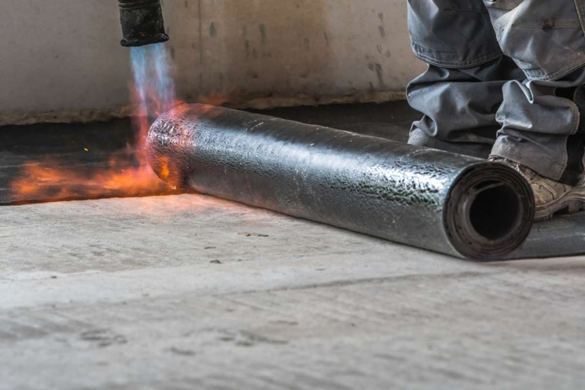 Installation by heating and melting of bitumen rolls by torch to flame, sealings and coatings concept