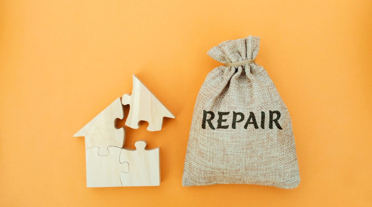 The word repair next to a puzzle home, roof repair concept