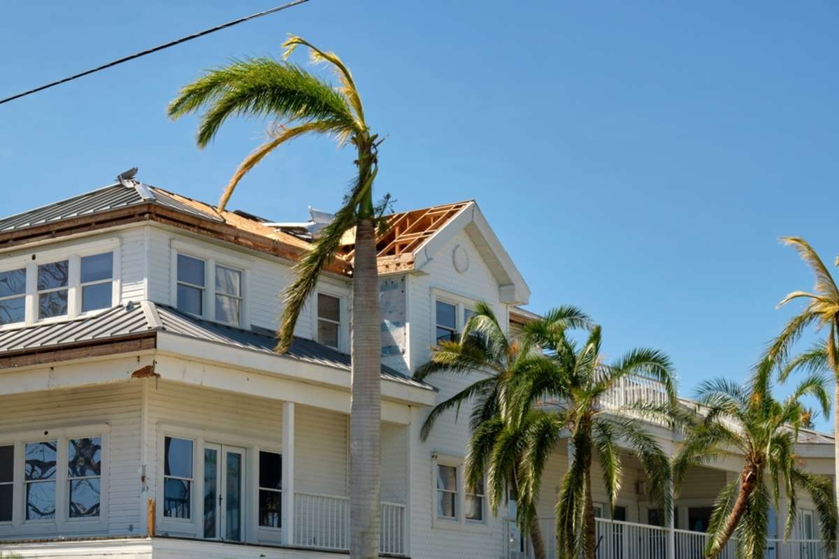 Damaged house roof with missing shingles after hurricane Ian in Florida