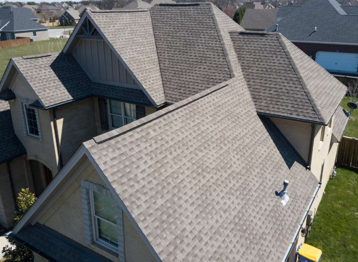 Residential shingle roof using ridge vent s with gables visible