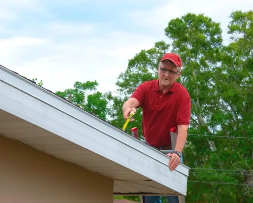 A_man_on_a_residential_roof_performing_a_professional_roof_inspection
