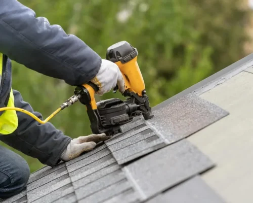 A_roofing_contractor_installing_asphalt_shingles_on_a_home