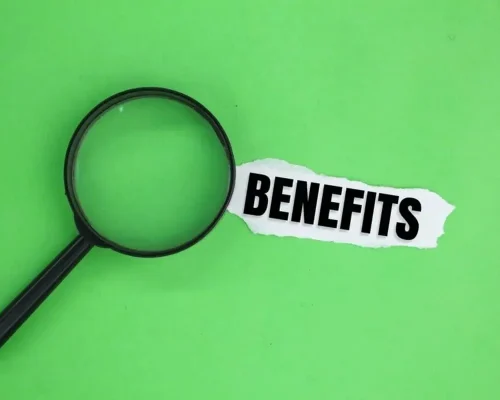 A_torn_green_background_showing_the_word_benefits_next_to_a_magnifying_glass