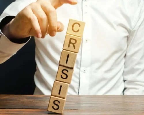 The_word_crisis_spelled_on_block_letters_falling_over,_emergency_roof_repair_concept