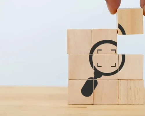 Wooden_blocks_stacked_on_top_of_each_other_showing_a_magnifying_glass